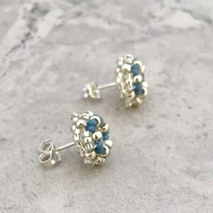 Puede incluir: Un par de pendientes de bot&oacute;n de plata con detalles de cuentas azules. Los pendientes son peque&ntilde;os y delicados, y ser&iacute;an un gran regalo para un amigo o un ser querido.