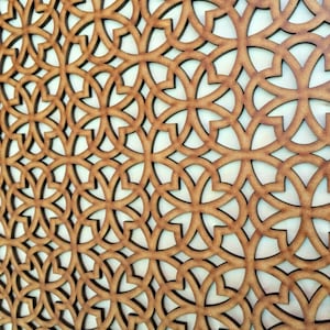 May include: A close-up of a brown wooden decorative panel with a repeating geometric pattern of interlocking circles and curves.