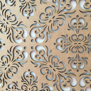May include: A brown wooden panel with a decorative cut-out design featuring intricate swirls and floral patterns.