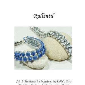 Könnte beinhalten: Zwei Perlenarmbänder, eines blau und eines weiß, mit silbernen Verschlüssen. Die Armbänder liegen auf einem grauen Steinuntergrund. Der Text "Rullentil" befindet sich oben im Bild. Der Text "Stitch this decorative bracelet using Rulla's, Two-Hole Lentil's, firepolish beads and seed beads" befindet sich unterhalb der Armbänder. Der Text "An original tutorial written by Anna Lindell 2014 © Tigerguld Sweden www.tigerguld.se www.tigerguld.com" befindet sich unten im Bild. Der Text "I am a Designer Creative ideas are my goods. Please respect my rights, and do not use my patterns without my permission." befindet sich in einem Kreis unten rechts im Bild.