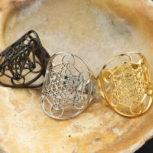 Pode incluir: Três anéis com um design geométrico. Os anéis são feitos de metal e são em prata, ouro e preto.