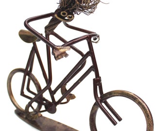 Recyclists sculpture of bicycle rider pedalling hard made from some recycled engineering parts