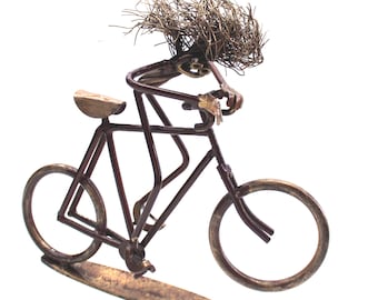 Recyclists sculpture of bicycle rider pedalling hard made from some recycled engineering parts