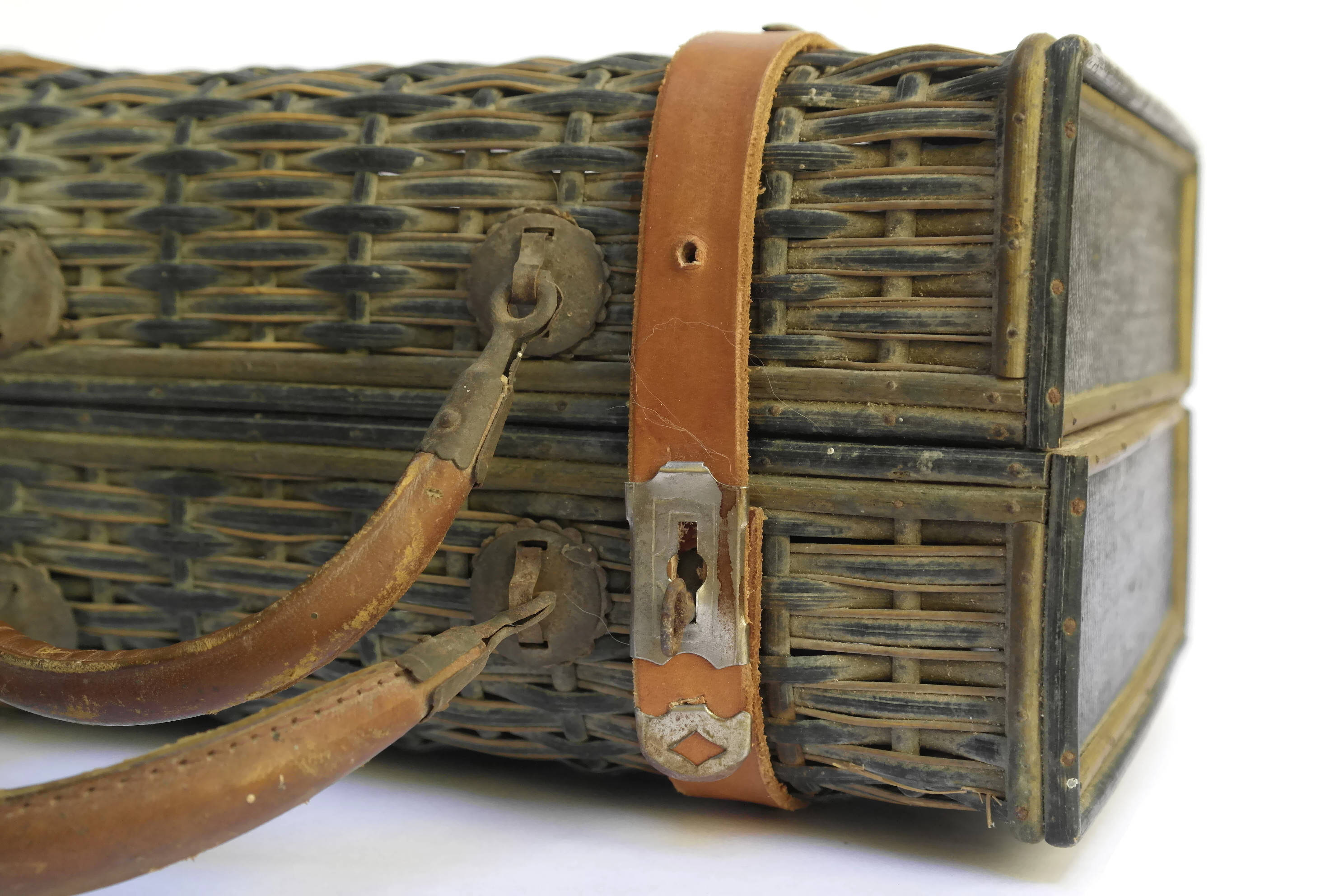 Antique Wicker Basket Suitcase with Brown Leather Straps and Handles.