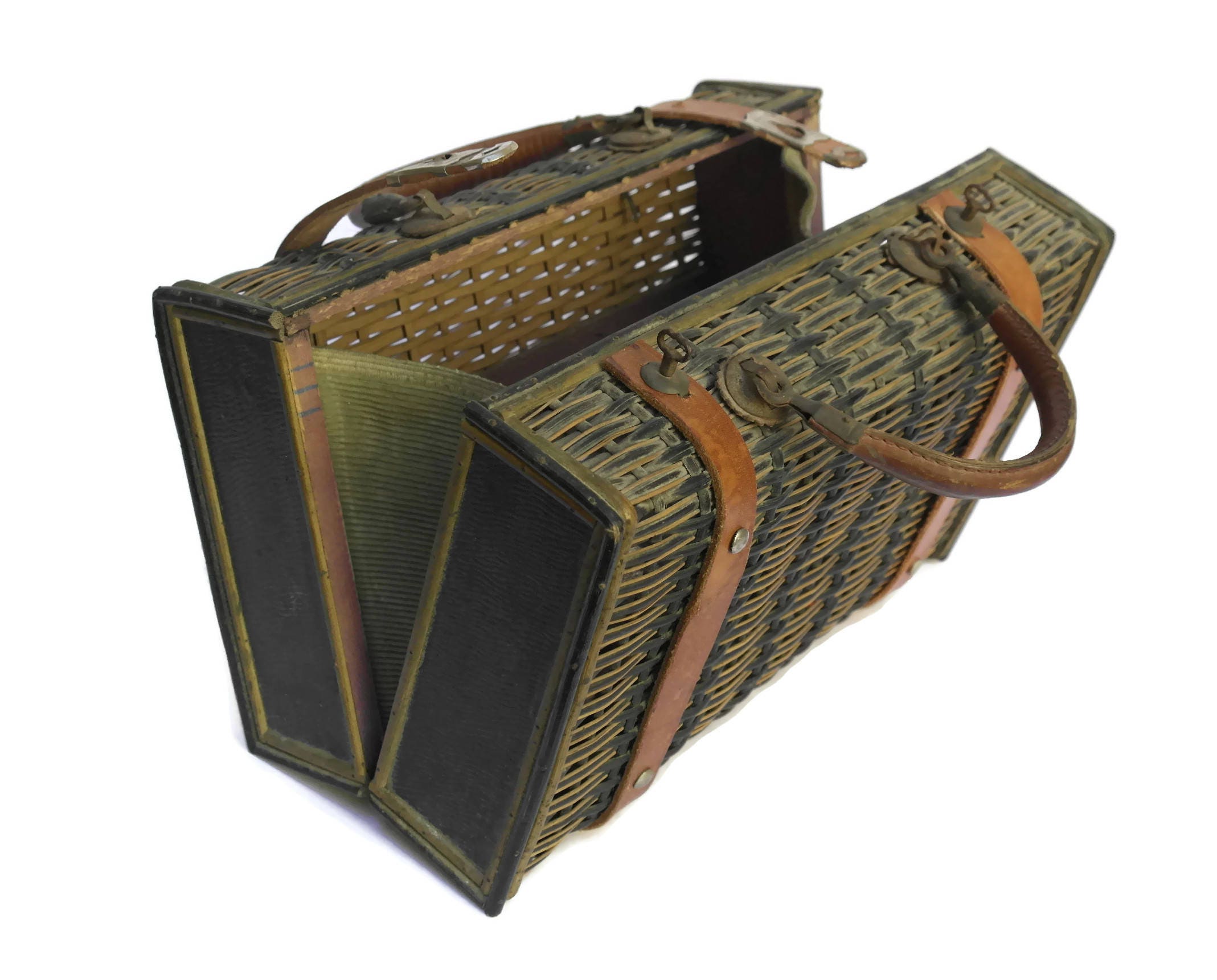 Antique Wicker Basket Suitcase with Brown Leather Straps and Handles.