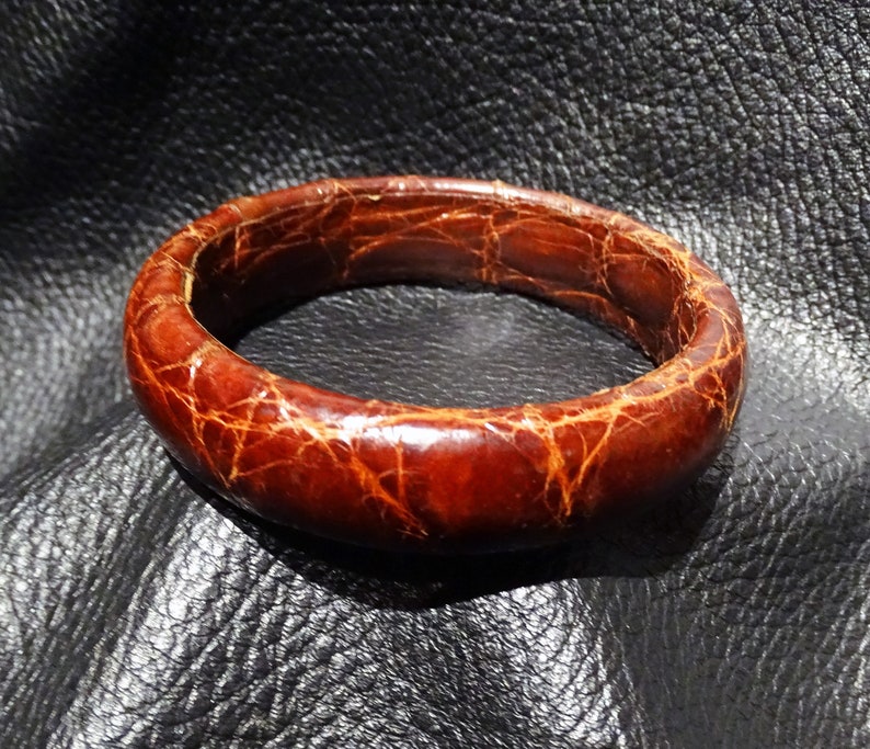 Pu&ograve; includere: Un braccialetto in pelle marrone con una superficie testurizzata. Il braccialetto &egrave; realizzato in vera pelle e ha un design semplice ed elegante.