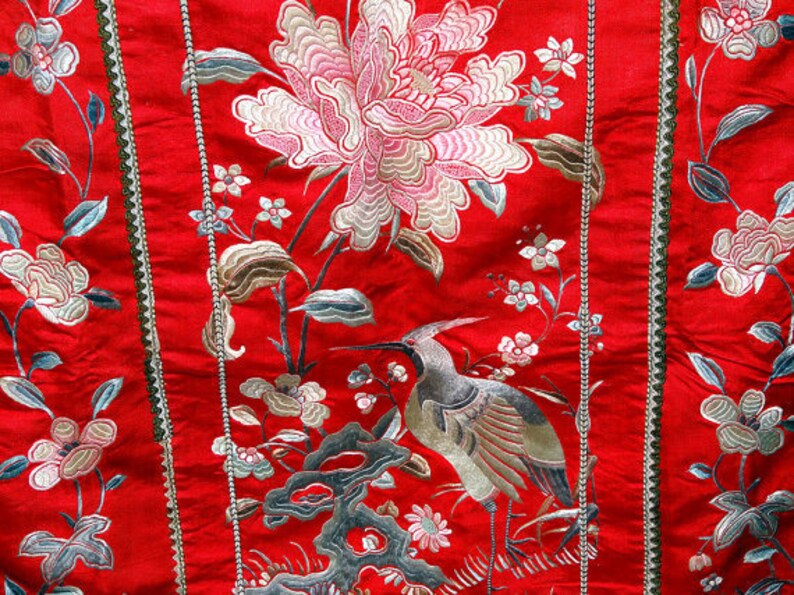K&ouml;nnte beinhalten: Roter Stoff mit gestickten Blumen und einem Vogel. Der Stoff hat einen goldenen Besatz an den R&auml;ndern.