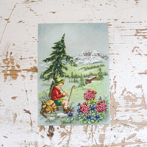 Cartolina illustrata d'epoca in stile tirolese inutilizzata con un bambino in montagna vestito con abiti tradizionali tirolesi