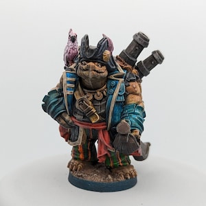 以下が含まれることがあります： 青い白の海賊船長の外套を着て、帽子をかぶり、剣を持っているカメのミニチュアフィギュア。カメは肩にピンクのオウムを乗せており、背中に2つの大砲を背負っている。