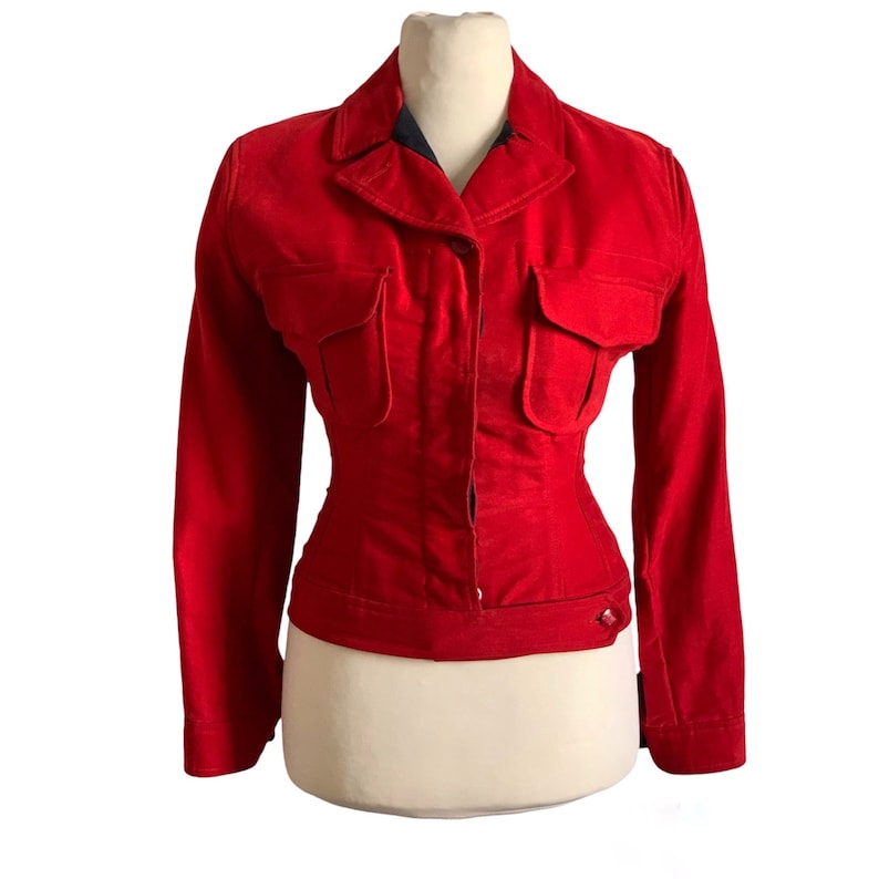 May include: A red velvet jacket with a button closure, two flap pockets, and a fitted waist.