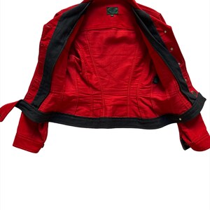 May include: Red denim jacket with black lining and gold buttons. The jacket is unzipped and turned inside out.