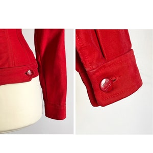 May include: A red denim jacket with a button closure and long sleeves. The jacket has a fitted silhouette and a classic design.