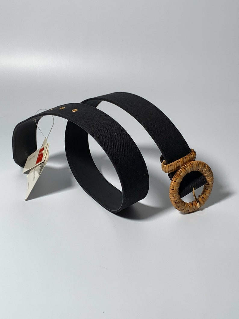 May include: A black woven belt with a large, round, natural woven buckle.