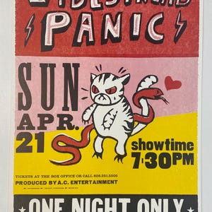 May include: A vintage concert poster for Widespread Panic, featuring a cartoon cat with a red snake. The poster has a red, pink, and yellow color scheme with the text "SUN APR. 21" and "showtime 7:30PM". The poster reads "ONE NIGHT ONLY ASHEVILLE CIVIC CENTER".