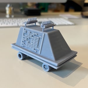 Könnte beinhalten: Ein graues 3D-gedrucktes Modell eines Star Wars Imperialen Truppentransporters, auch bekannt als 'TIE'-Jäger, mit einem detaillierten Design und zwei Sätzen von erhöhten, vertikalen, rechteckigen Balken oben.