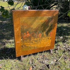 May include: A wooden folding screen with a vintage hunting scene illustration. The screen has a brown wood frame and a gold-toned background with a scene of people on horseback riding through a forest.