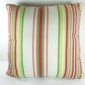 May include: A striped throw pillow with red, green, and white stripes. The pillow is made of a soft, woven fabric.