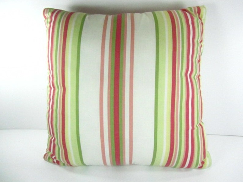 May include: A striped throw pillow with red, green, and white stripes. The pillow is made of a soft, woven fabric.