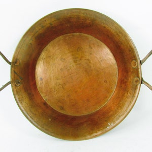 May include: A vintage copper pan with two wire handles. The pan has a hammered finish and is in good condition.