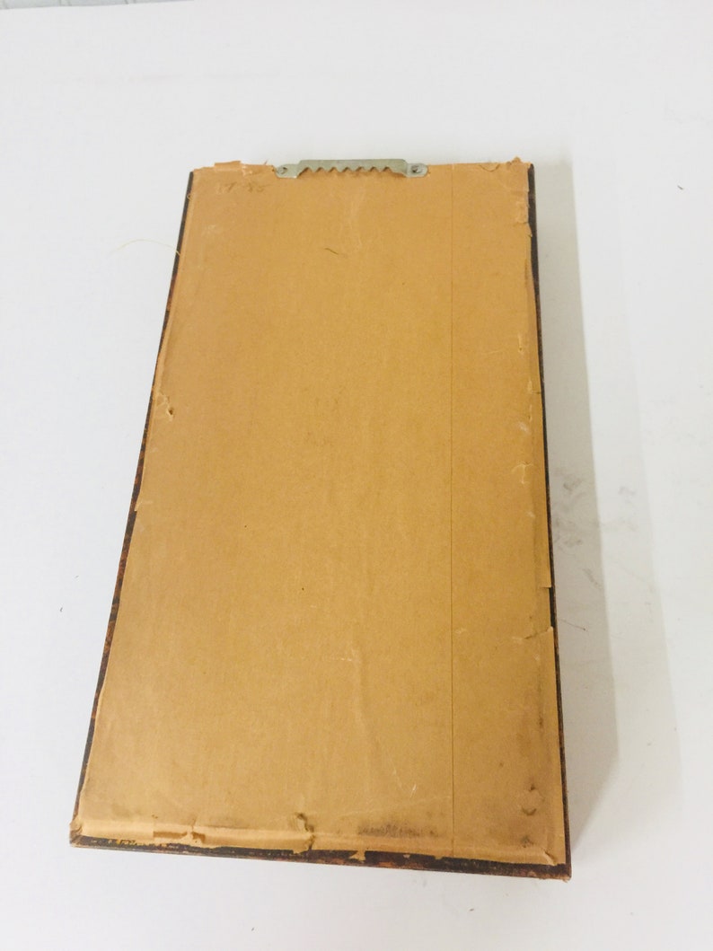 May include: A brown wooden picture frame with a brown paper backing. The frame has a sawtooth hanger on the back.