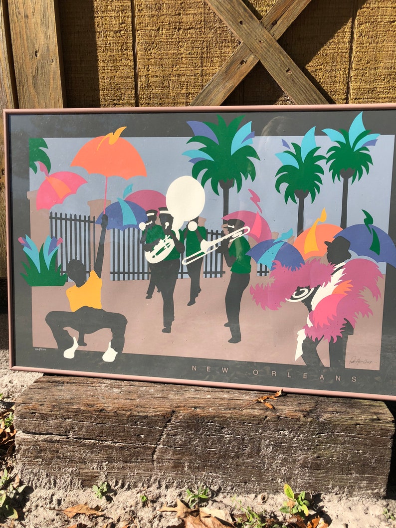 Puede incluir: Un p&oacute;ster vintage colorido con una silueta de una banda de marcha en Nueva Orleans. El p&oacute;ster presenta una paleta de colores vibrantes de rosa, azul, verde, amarillo y naranja. El texto "NEW ORLEANS" est&aacute; impreso en la parte inferior del p&oacute;ster.