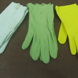 May include: Three pairs of gloves in different colors: light blue, green, and yellow. The gloves are made of a soft, smooth fabric.