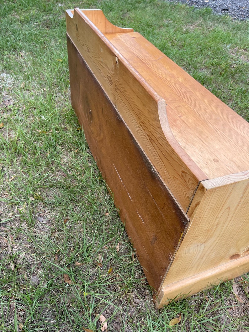 K&ouml;nnte beinhalten: Eine Holzaufbewahrungsbank mit einem Klappdeckel und einer nat&uuml;rlichen Holzoptik. Die Bank ist aus massivem Holz gefertigt und hat ein schlichtes, rustikales Design.