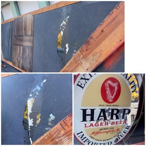 K&ouml;nnte beinhalten: Ein altes, verwittertes Metallschild, das f&uuml;r Harp Lager Bier wirbt. Das Schild ist rund und hat einen goldenen Hintergrund mit einem roten Harfenlogo und dem Text "Harp Lager Beer" in Schwarz. Das Schild ist teilweise besch&auml;digt, einige Farbe ist abgeplatzt.