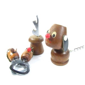 May include: A collection of vintage wooden bottle openers and corkscrews. The set includes a dog-shaped corkscrew with a red nose and a metal corkscrew tail, and two other openers with cartoon faces.