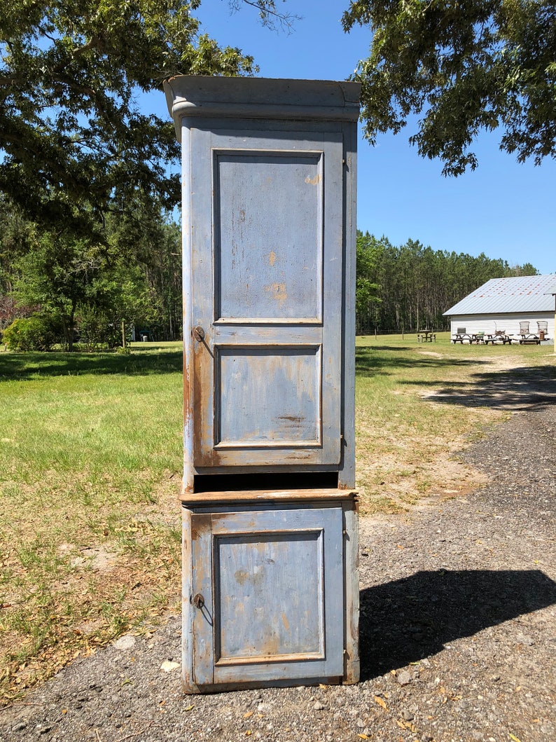 May include: A tall, blue, wooden cabinet with two doors. The cabinet has a distressed finish and is in good condition.