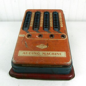 May include: Vintage red and blue metal adding machine with the text "Wolverine Made in USA Adding Machine Patent Pending" on the front.