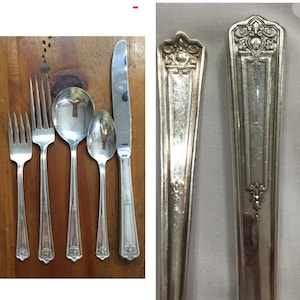 Puede incluir: Conjunto de cinco piezas de cubiertos plateados, que incluyen un cuchillo, un tenedor y tres cucharas. Los cubiertos tienen un diseño adornado con un motivo floral.