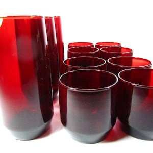 May include: Set of ten red glass tumblers. The tumblers are all the same size and shape, and they have a smooth, rounded bottom.