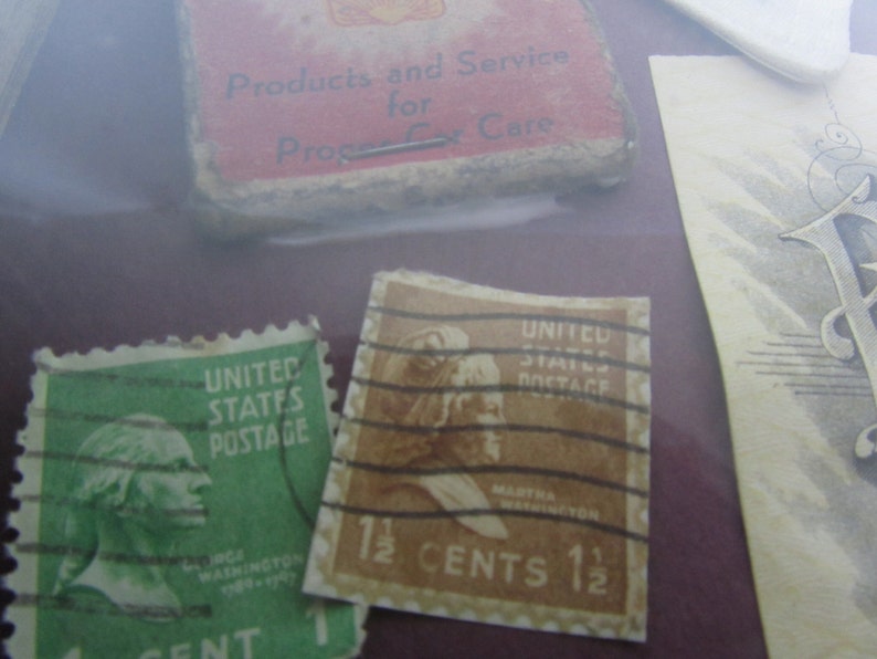 Puede incluir: Dos sellos postales vintage de los Estados Unidos. El sello verde presenta un retrato de George Washington y el texto "United States Postage". El sello marr&oacute;n presenta un retrato de Martha Washington y el texto "United States Postage 1 1/2 Cents 1 1/2".