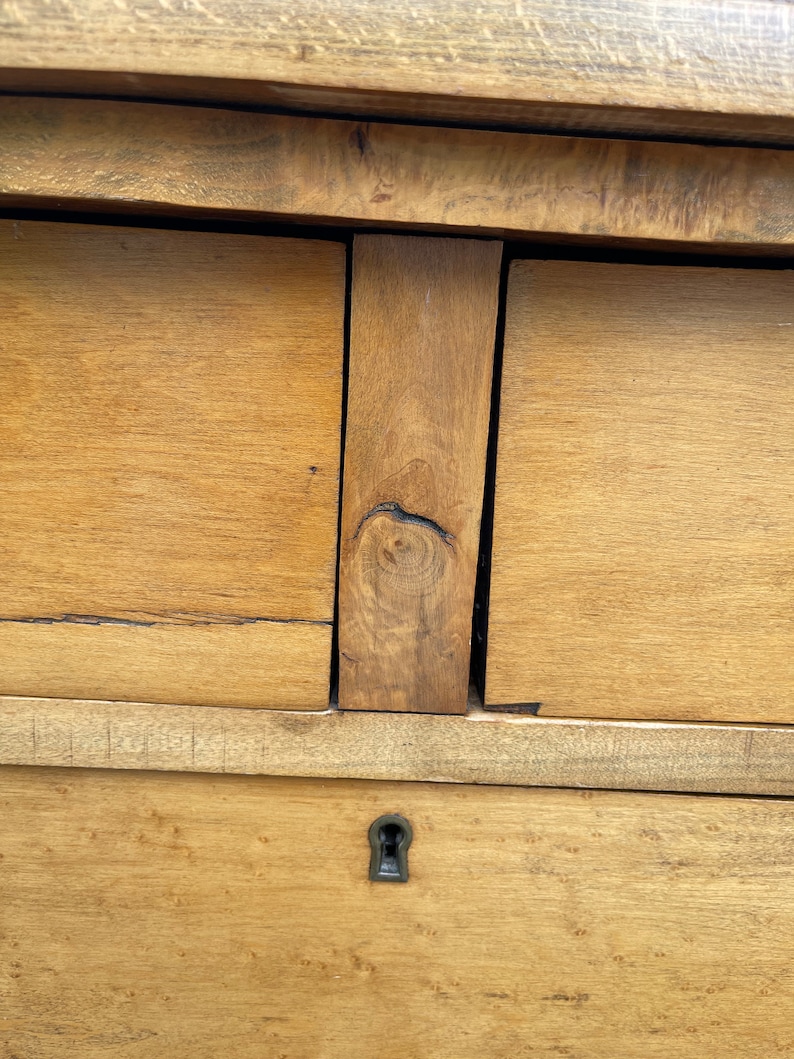 Puede incluir: Primer plano de una c&oacute;moda de madera con dos cajones y una cerradura. Los cajones son de madera clara con un acabado natural. La cerradura se encuentra en el caj&oacute;n inferior.