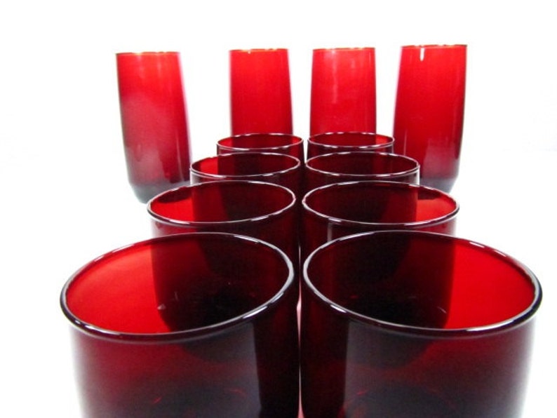 May include: Set of ten red glass tumblers. The glasses are arranged in a pyramid shape, with the tallest glasses at the back and the shortest glasses at the front.