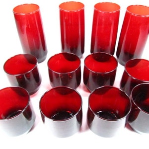 May include: Set of 12 red glass tumblers, some tall and some short. The glasses are all a deep red colour and have a smooth, rounded shape.