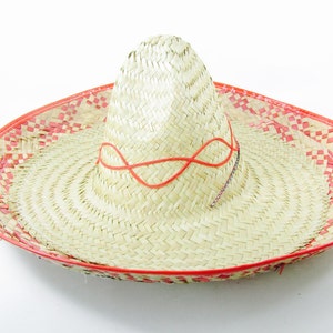 May include: A large, straw sombrero with a red and white checkered band around the brim. The hat has a red ribbon tied around the crown.