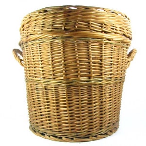 May include: A large, natural woven wicker basket with two handles. The basket is made of light brown wicker and has a round shape.