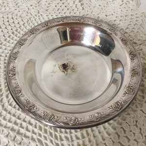 Puede incluir: Un plato de servir de plata con un dise&ntilde;o de rosas alrededor del borde.