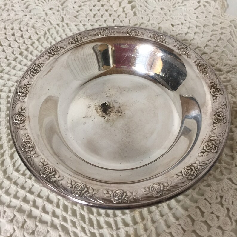 Puede incluir: Un plato de servir de plata con un dise&ntilde;o de rosas alrededor del borde.
