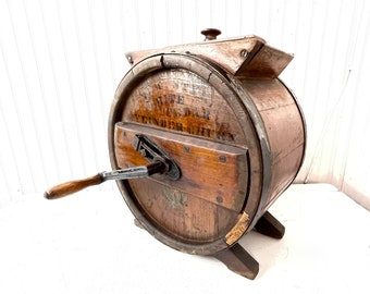 May include: Antique wooden butter churn with a hand crank and a wooden lid. The churn is labeled "SUPER SUPERIOR BUTTER CHURN" and has a decorative eagle design.
