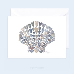 May include: A white card with a gray and brown stone heart design in the shape of a seashell. The text "loverrocksme" is at the bottom of the card.