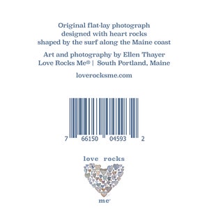 May include: A photograph of a heart made of heart-shaped rocks. The text "love rocks me" is below the heart. The image also includes a barcode with the numbers 7 66150 04593 2.