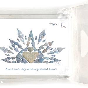 May include: A white card with a blue and gray stone heart design. The text "Start each day with a grateful heart" is printed below the design.