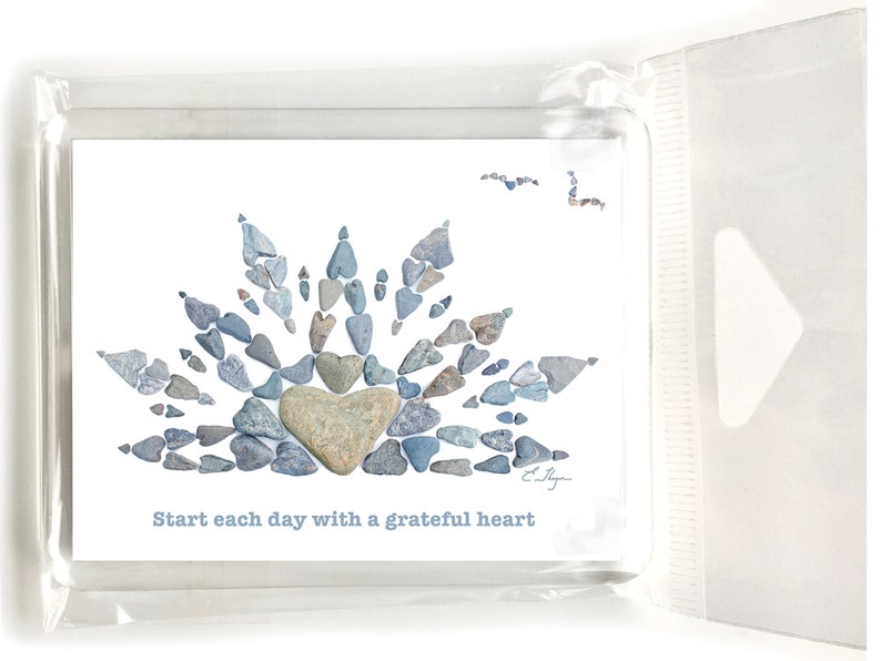 May include: A white card with a blue and gray stone heart design. The text "Start each day with a grateful heart" is printed below the design.