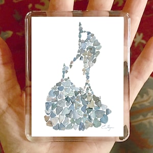 May include: A white background with a blue and gray mosaic of small stones in the shape of the island of Martha's Vineyard. The artist's signature is in the bottom right corner.