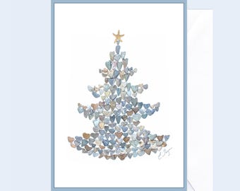 May include: A Christmas card featuring a tree made of heart-shaped stones in shades of blue, gray, and brown. A gold starfish tops the tree. The card is framed in a light blue border and includes a white envelope.