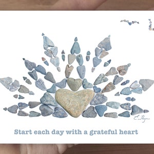 May include: A white card with a blue stone heart surrounded by smaller blue stones in the shape of a sunburst. The text "Start each day with a grateful heart" is printed below the image.