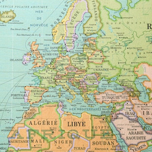 K&ouml;nnte beinhalten: Eine Vintage-Weltkarte mit hellblauem Hintergrund und gr&uuml;nen, gelben und braunen R&auml;ndern. Die Karte zeigt die Kontinente Europa, Afrika und Asien. Die Karte ist mit den Namen von L&auml;ndern und St&auml;dten beschriftet.